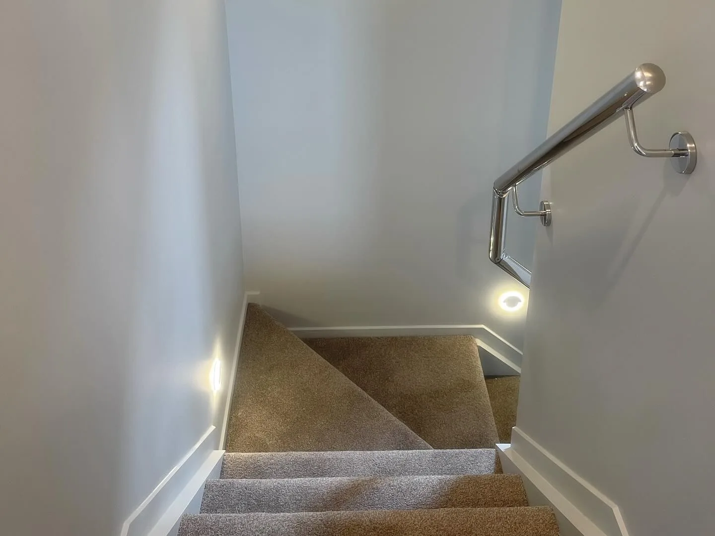 Interior staircase with freshly finished light walls and handrail